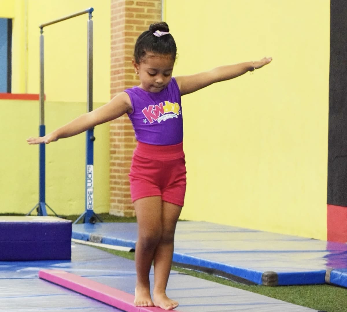 Criança equilibrando-se na trave na Kinder
